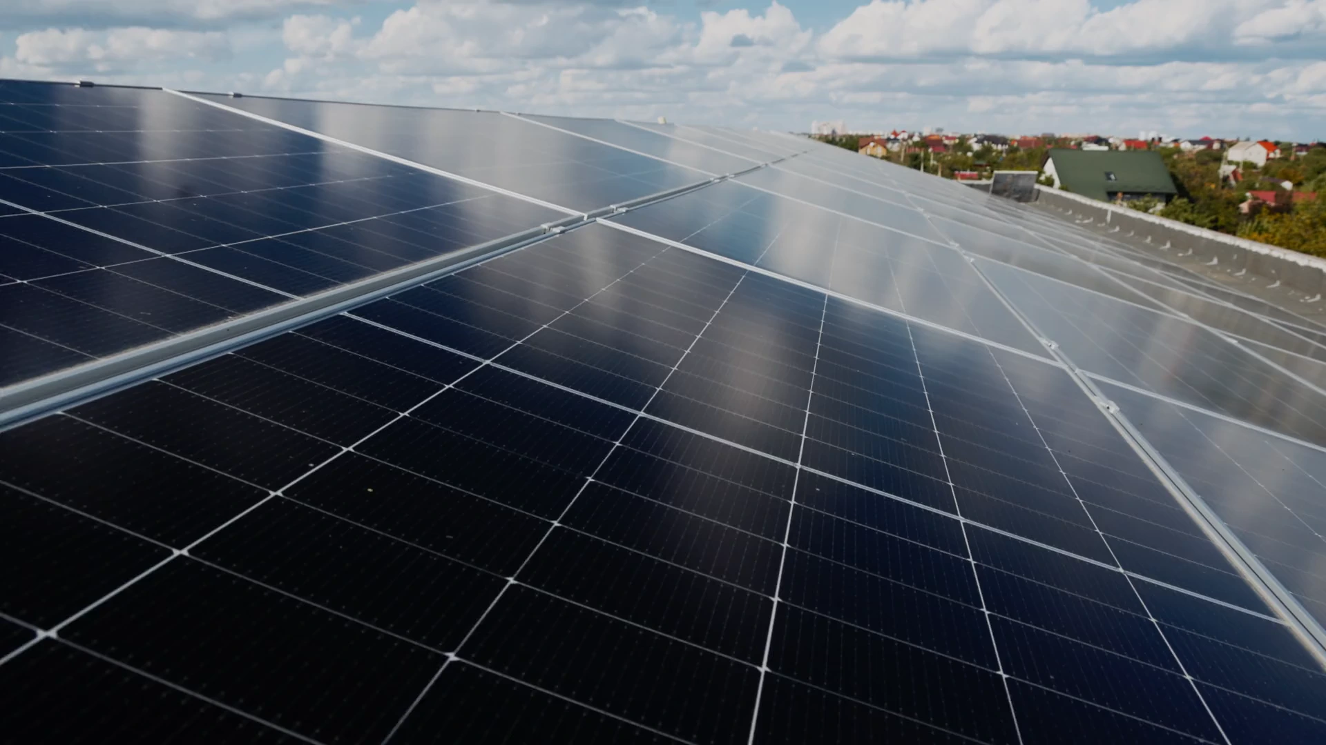 Solar panels on a rooftop beneath a bright sky