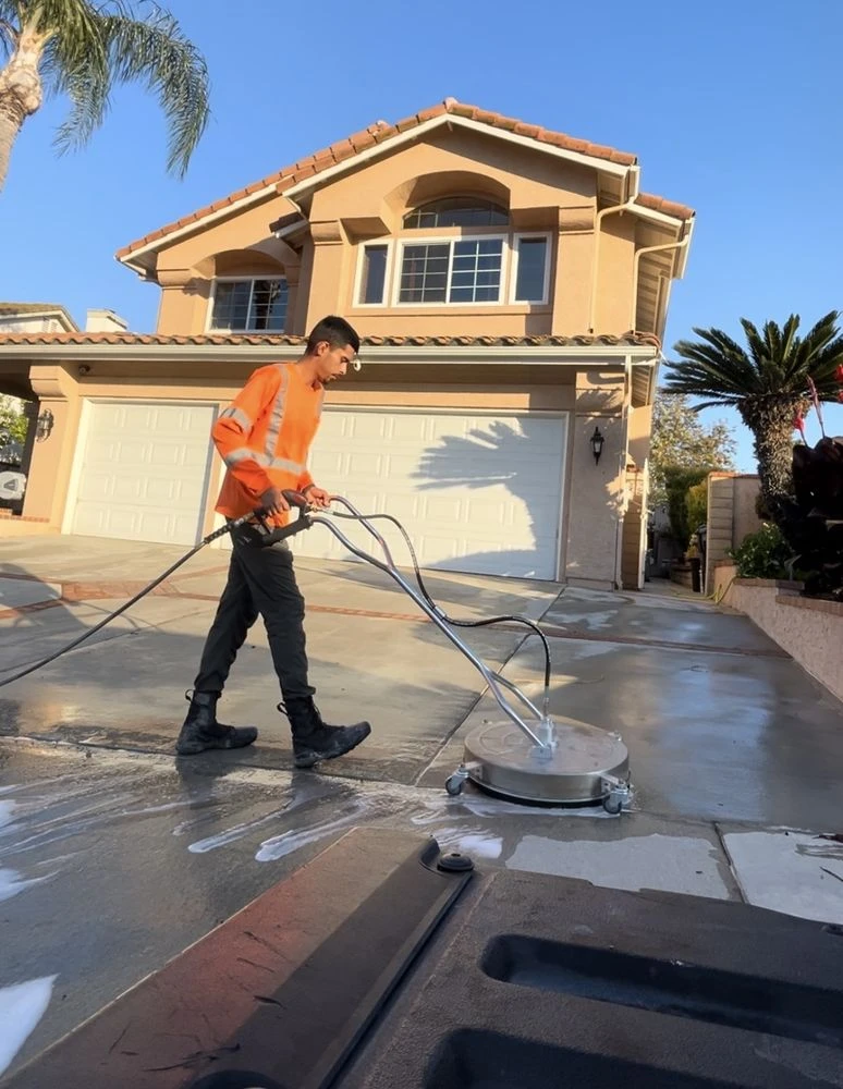 Pressure washing a driveway at a Wiped Clean customer property