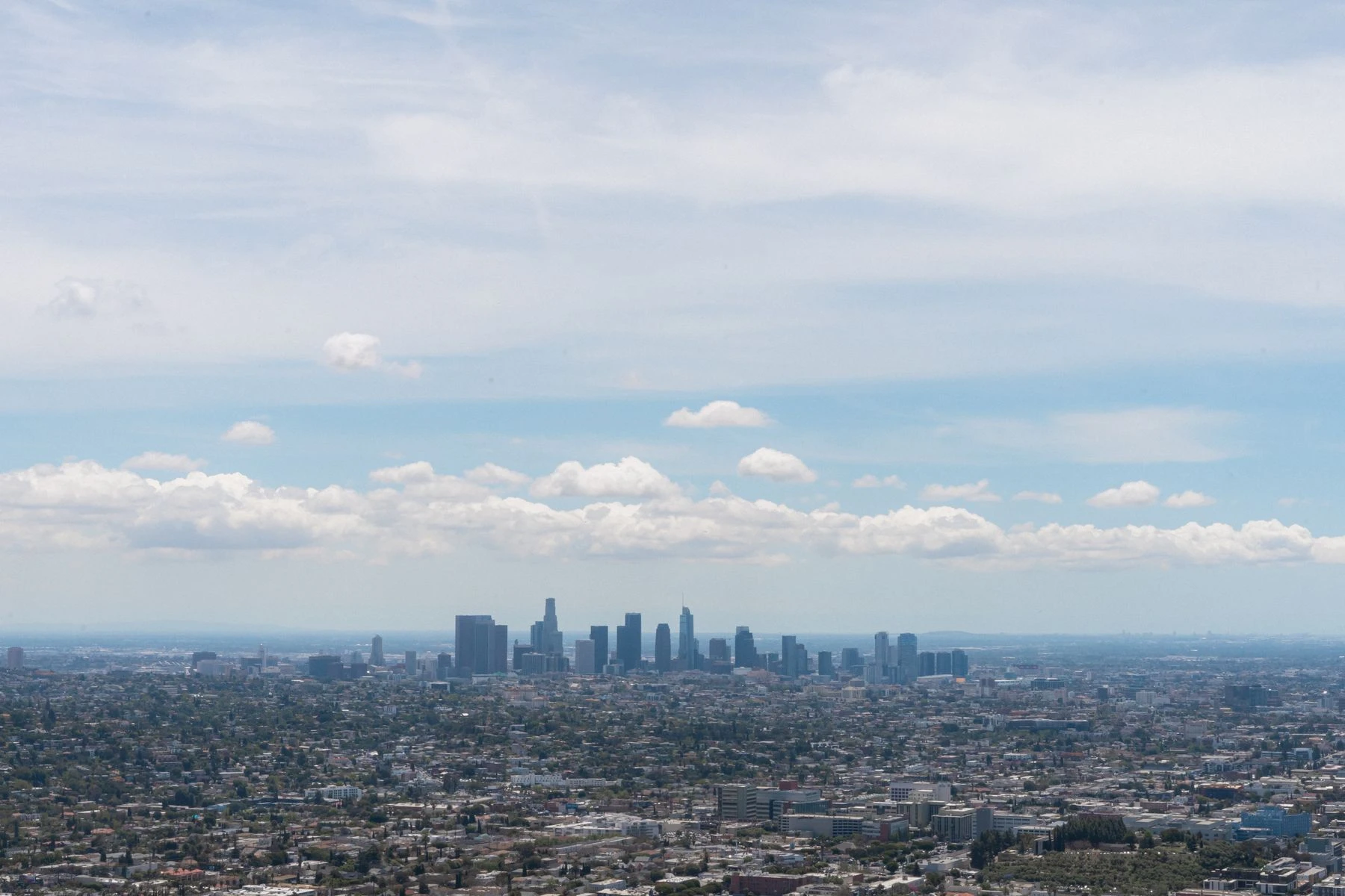 Elevated panoramic view over Los Angeles and its skyline beneath a bright blue sky
